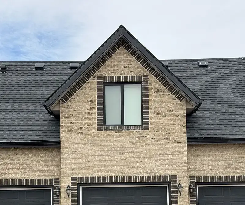 A roofing technician reviewing storm-related roof damage.