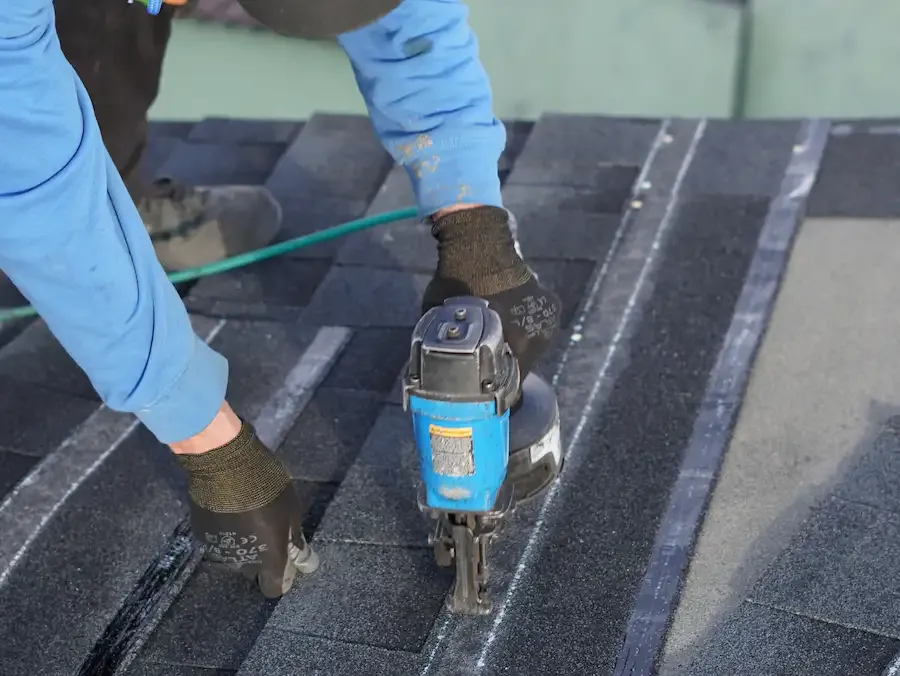 A roofing professional performing a close-up roof repair.